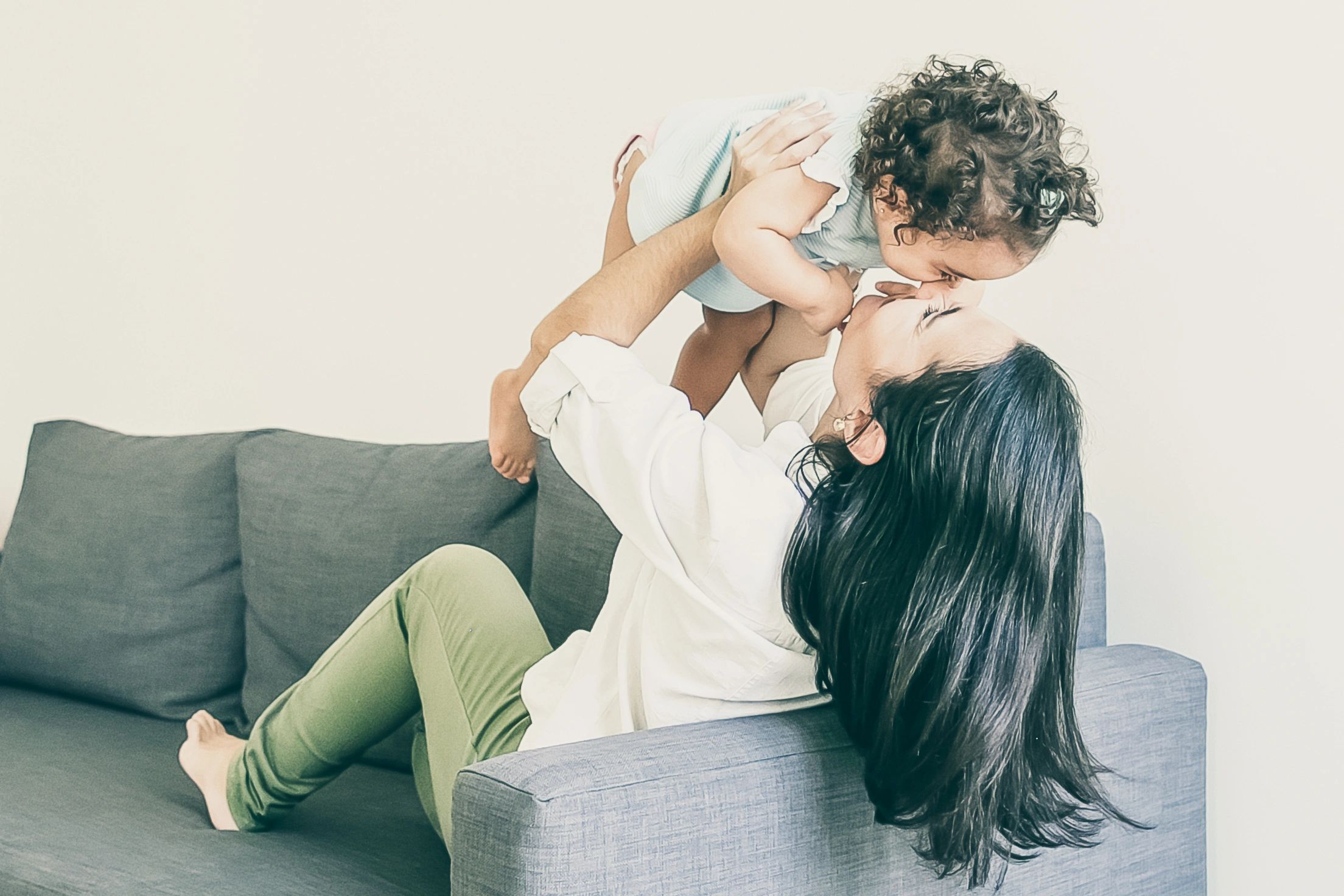 Joyful mother lifting her baby