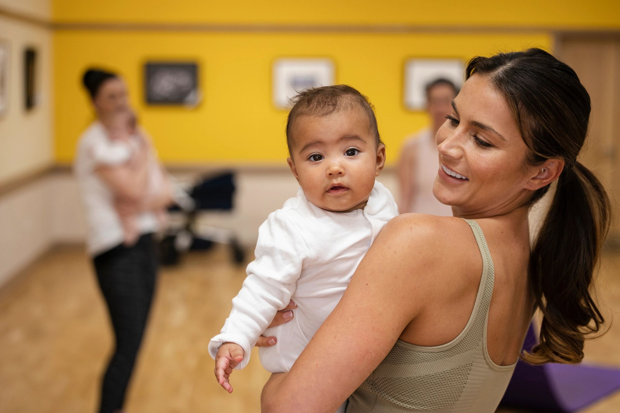 Mother holding her smiling baby daughter