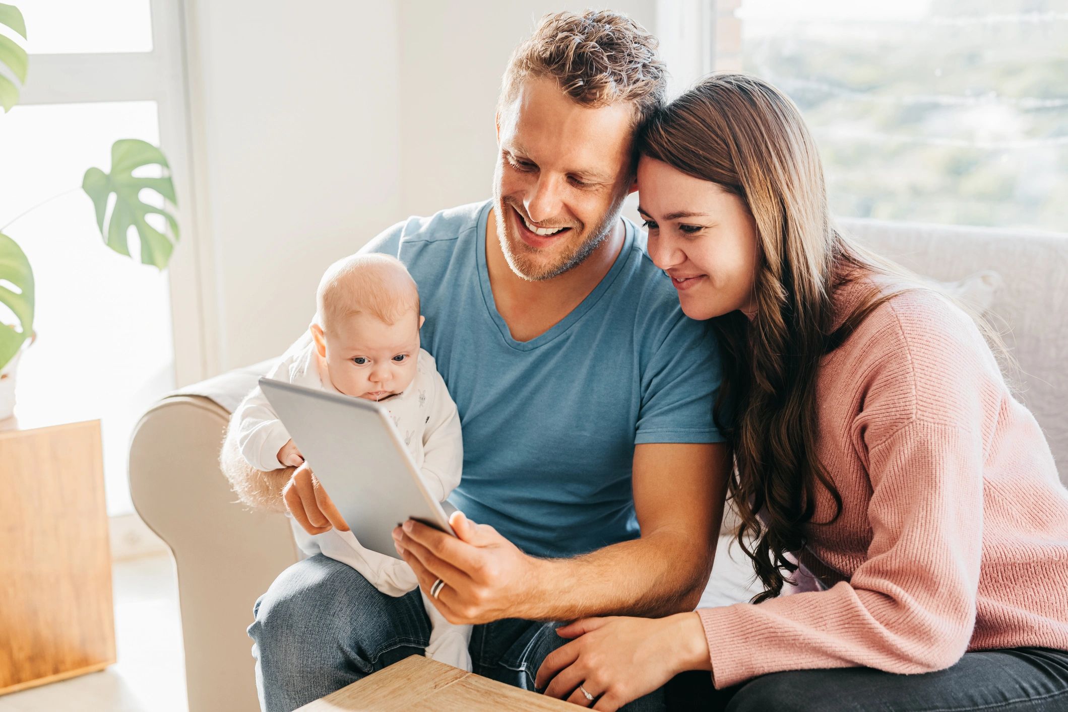 Young parents with baby using a tablet at home